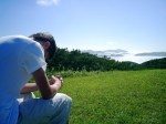 Man-praying-in-field-near-ocean